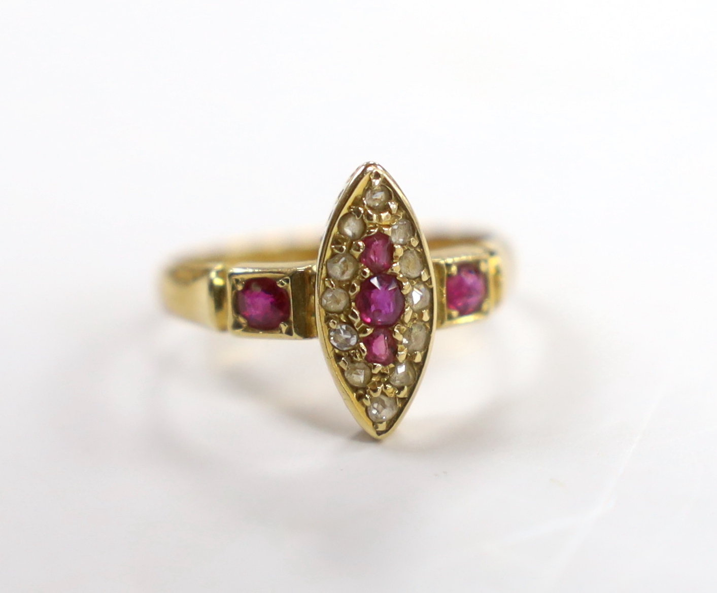 A late Victorian 18ct gold, ruby and diamond cluster set navette shaped ring, size J, gross weight 2.4 grams.